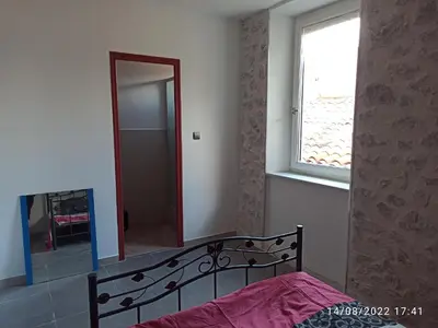 a bedroom with a bed and a mirror and a window at Porte Rouge in Capendu