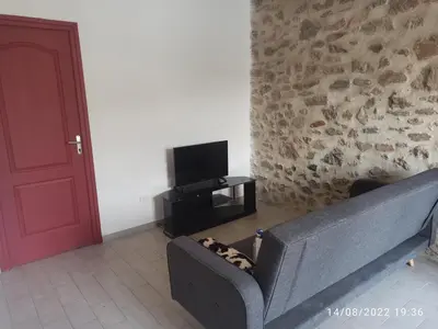 a living room with a couch and a tv at Porte Rouge in Capendu
