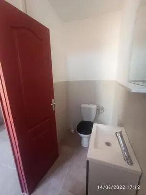 a bathroom with a toilet and a red door at Porte Rouge in Capendu