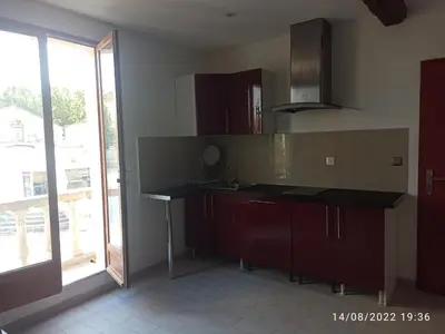a kitchen with a counter and a large window at Porte Rouge in Capendu