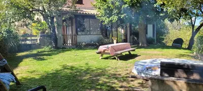 a yard with a bench and a house at Grande maison de montagne rénovée, du charme in Rodome