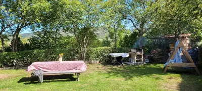 a picnic table in a backyard with a grill and a table sidx sidx at Grande maison de montagne rénovée, du charme in Rodome