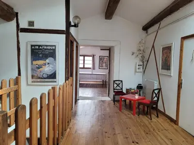 a hallway with a wooden floor and a red table at Grande maison de montagne rénovée, du charme in Rodome