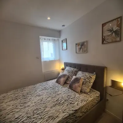 a bedroom with a bed with two pillows on it at Très joli appartement 2 pièces, centre-ville in Tuchan