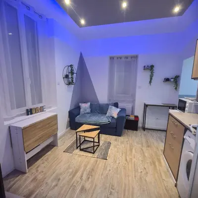 a living room with a blue couch and a table at Très joli appartement 2 pièces, centre-ville in Tuchan