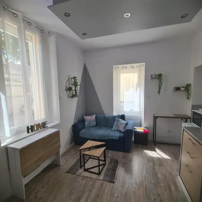 a living room with a blue couch and a table at Très joli appartement 2 pièces, centre-ville in Tuchan