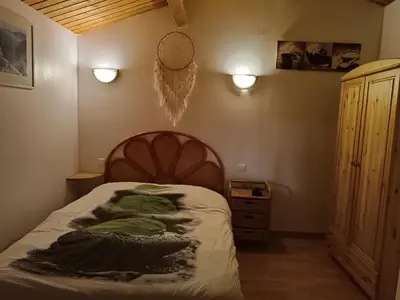 a bedroom with a bed and a cabinet and lights at GITE DE KATE in Albières
