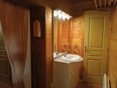a bathroom with a sink and a mirror and a door at GITE DE KATE in Albières
