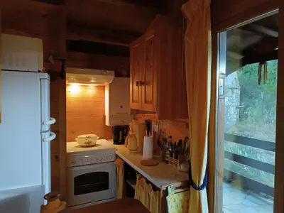 a small kitchen with a stove and a refrigerator at GITE DE KATE in Albières