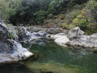 a pool of water in a river with rocks at GITE DE KATE in Albières