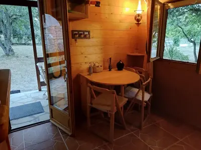 a dining room with a table and a glass door at GITE DE KATE in Albières