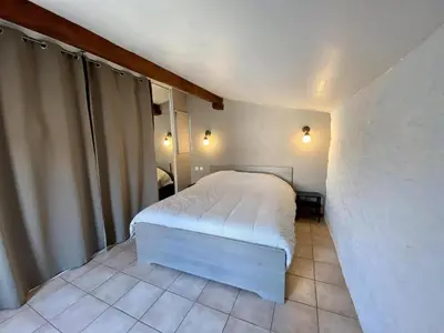 a small bedroom with a white bed in a room at Le Gîte du Canal, à Homps. in Homps