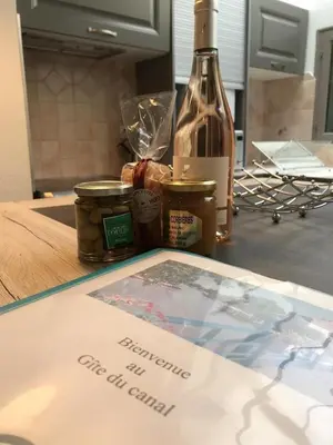 a bottle of wine and jars of food on a table at Le Gîte du Canal, à Homps. in Homps