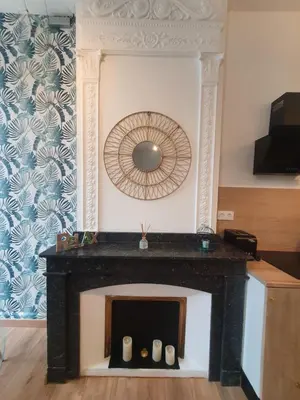a fireplace in a living room with a mirror at A l ombre des remparts 3 in Carcassonne