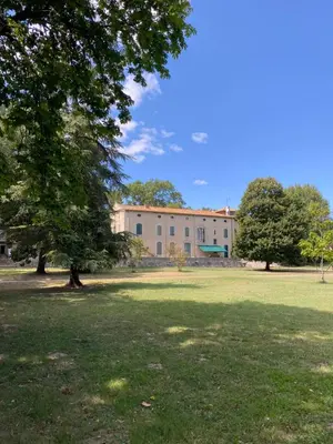 a large building with a tree in the middle of a field at Gîte Superbe L'Ecurie XIXème in Sallèles-dʼAude