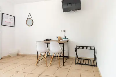 a table with two chairs and a television in a room at Logis hôtel restaurant Le clos saint loup in Bram