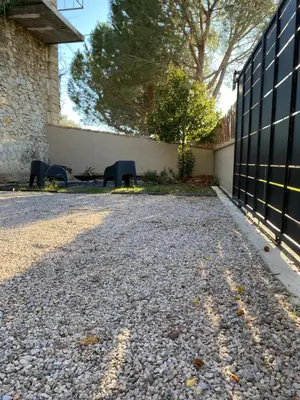 two chairs sitting on a gravel road next to a fence at Joli gîte chic et cosy entre mer et Narbonne in Narbonne