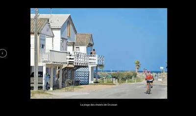 a person riding a bike down a street next to houses at Joli gîte chic et cosy entre mer et Narbonne in Narbonne