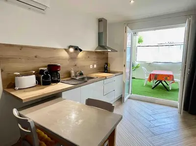a kitchen with a counter top and a table with a table at Appartement Terrasse proche centre et canal in Narbonne