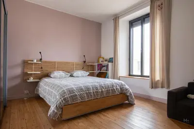 a bedroom with a bed with a wooden headboard and a window at Maison, piscine & vue sur la Cité de Carcassonne in Carcassonne