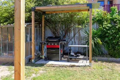 a grill under a cover in a yard at Maison, piscine & vue sur la Cité de Carcassonne in Carcassonne