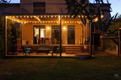 a pergola with lights on a backyard at night at Maison, piscine & vue sur la Cité de Carcassonne in Carcassonne