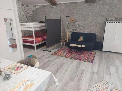 a living room with a couch and a bunk bed at Gite Studio Les Maisons de Gaïa in Tuchan