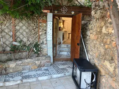an open door to a stone building with a television outside at Gite Studio Les Maisons de Gaïa in Tuchan