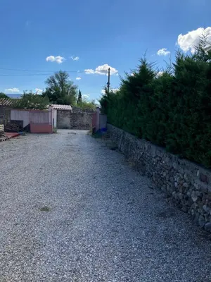 a gravel road next to a stone wall at Gite Studio Les Maisons de Gaïa in Tuchan