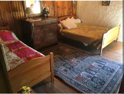 a bedroom with two beds and a dresser and a rug at Grand Appartement 6 pers,lumineux,avec terrasse Sud de France in Tuchan