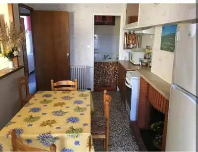 a kitchen with a table and a kitchen with a table and a kitchen at Grand Appartement 6 pers,lumineux,avec terrasse Sud de France in Tuchan