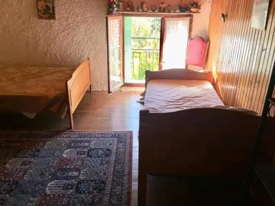 a bedroom with two beds and a window and a rug at Grand Appartement 6 pers,lumineux,avec terrasse Sud de France in Tuchan