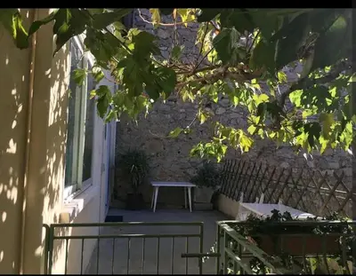 a bench sitting on a porch next to a building at Grand Appartement 6 pers,lumineux,avec terrasse Sud de France in Tuchan