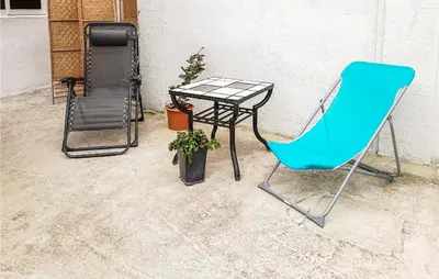 a blue chair sitting next to a table and a table at Awesome Home In Villeneuve-Lès-Montréa in Villeneuve-lès-Montréal