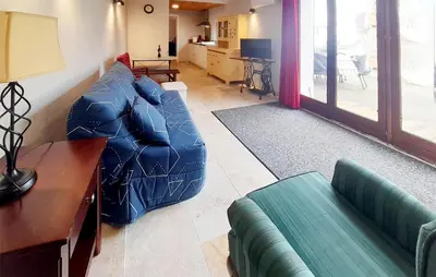 a living room with a blue couch and a table at Awesome Home In Villeneuve-Lès-Montréa in Villeneuve-lès-Montréal