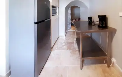 a kitchen with a table and a refrigerator at Awesome Home In Villeneuve-Lès-Montréa in Villeneuve-lès-Montréal