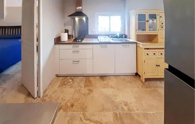 a kitchen with white cabinets and a wooden floor at Awesome Home In Villeneuve-Lès-Montréa in Villeneuve-lès-Montréal