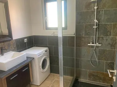 a bathroom with a washing machine and a sink at Gîte Ardoise in Castelnaudary