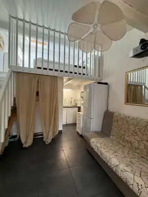 a living room with a couch and a ceiling fan at La maisonnette de Gruissan in Gruissan