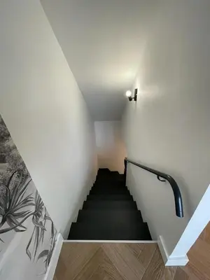 a stairway with a black and white staircase at Appartement cosy avec vue imprenable sur la cité in Carcassonne
