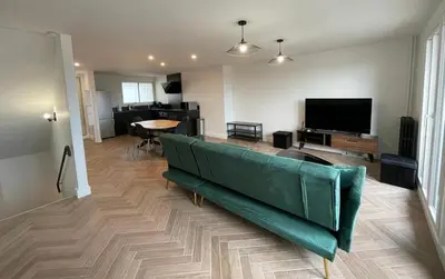 a living room with a green couch and a table at Appartement cosy avec vue imprenable sur la cité in Carcassonne