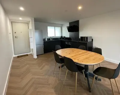 a kitchen with black cabinets and a microwave and a refrigerator at Appartement cosy avec vue imprenable sur la cité in Carcassonne