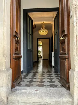 a hallway with a checkered floor and a chandelier at SalutBB Chambre d'hote in Carcassonne