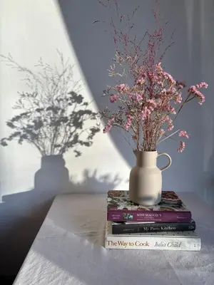 a vase sitting on top of a stack of books with flowers at SalutBB Chambre d'hote in Carcassonne
