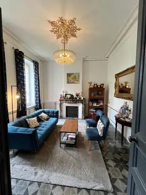 a living room with blue couches and a chandelier at SalutBB Chambre d'hote in Carcassonne