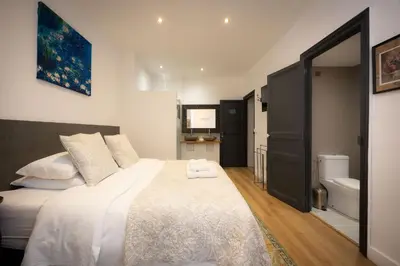 a bedroom with a bed and a bathroom with a sink at SalutBB Chambre d'hote in Carcassonne