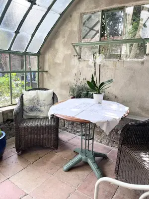 a table and two chairs and a table with a plant on it at SalutBB Chambre d'hote in Carcassonne