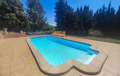 a swimming pool with chairs on a patio at Awesome Home In Ferrières-Poussarou in Ferrières-Poussarou
