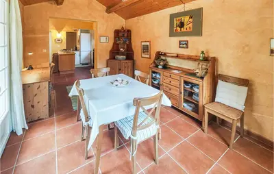 a kitchen and dining room with a table and chairs at Awesome Home In Ferrières-Poussarou in Ferrières-Poussarou