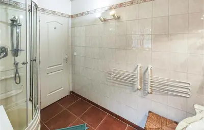 a bathroom with a shower and a tiled wall at Awesome Home In Ferrières-Poussarou in Ferrières-Poussarou